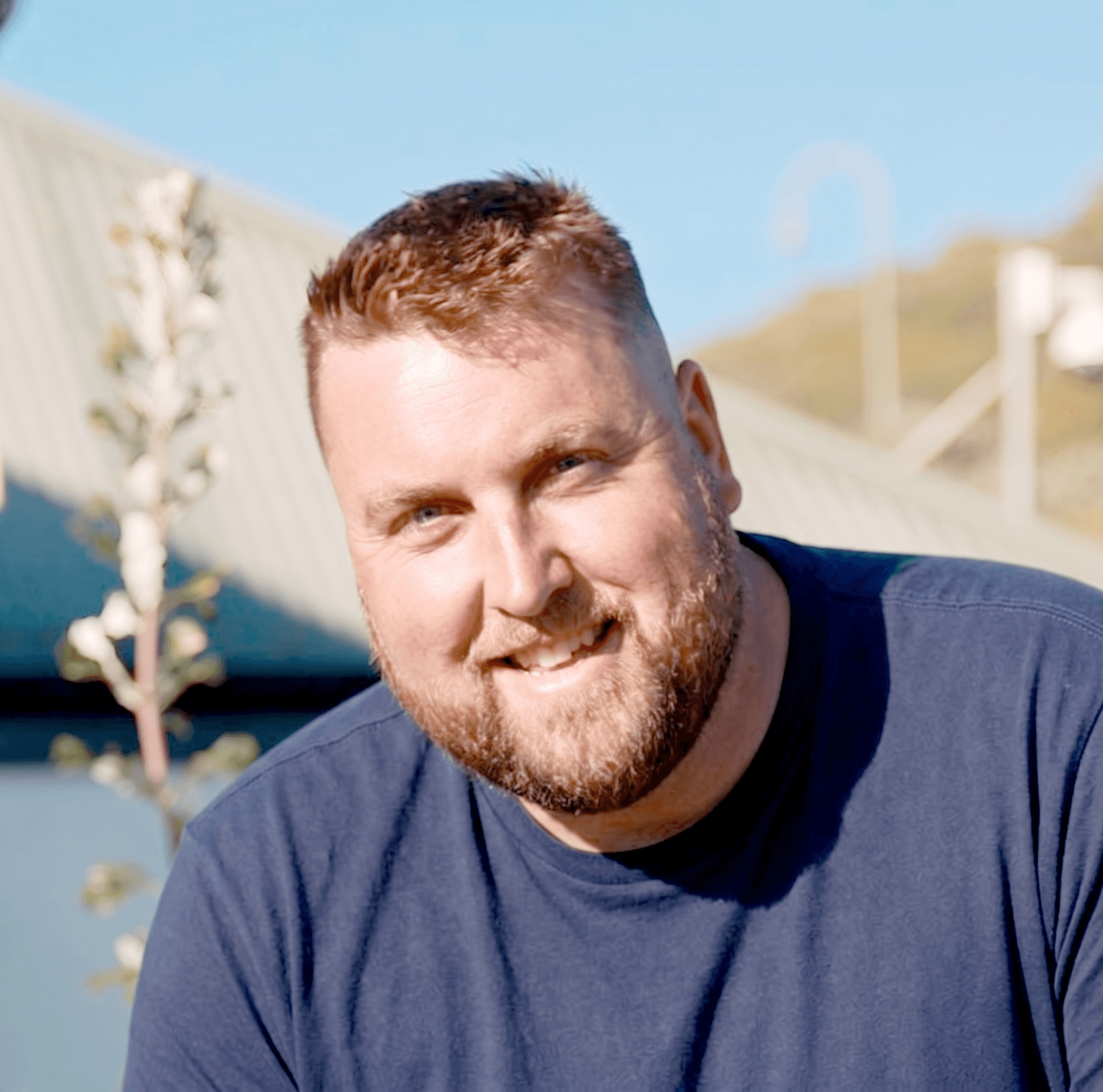 Simon Tolliday, owner of Tolliday Gardens, smiling in a rose garden